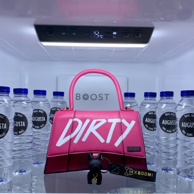 Mala rosa com texto DIRTY dentro de frigorífico entre garrafas de água AUGUSTA