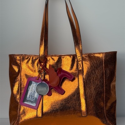 Mala de mão metálica dourada com acessórios pendurados