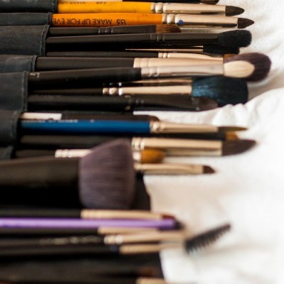 Conjunto de pincéis de maquilhagem variados sobre tecido branco