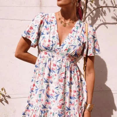 Vestido curto feminino com padrão floral colorido em fundo branco