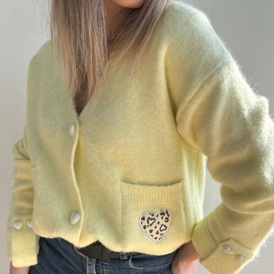 Cárdigan amarelo claro com botões de coração e bolso com coração estampado.