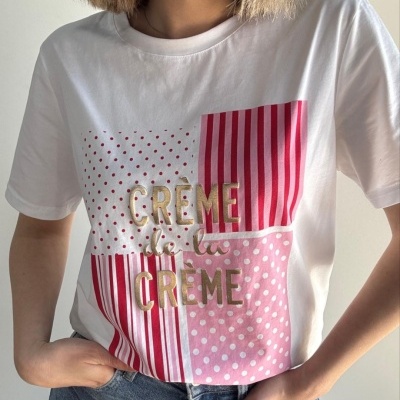 T-shirt branca com estampado riscado e bolinhas em vermelho e rosa com texto dourado