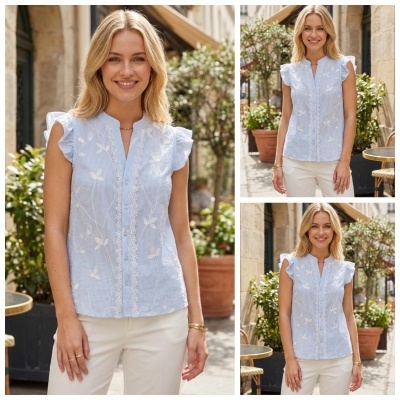 Blusa azul clara com riscas e bordados florais, usada por mulher ao ar livre.