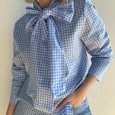 Blusa xadrez azul e branco com laço no pescoço usada com calças de ganga