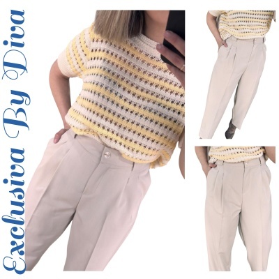 Conjunto de camisola de malha creme e amarelo com calças bege claro.