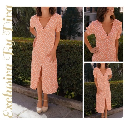 Vestido midi laranja com padrão branco, botões frontais e fenda, usado por mulher no exterior.