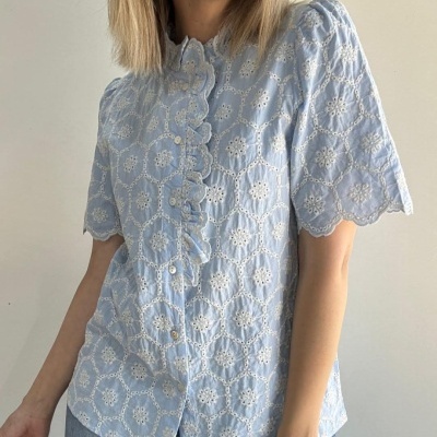 blusa azul clara com bordados brancos e botões frontais