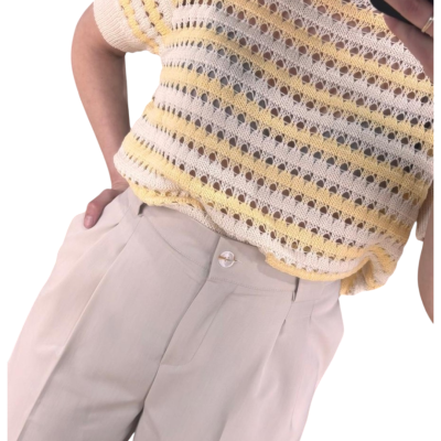 T-shirt de malha com riscas amarelas e creme combinada com calças bege claro.