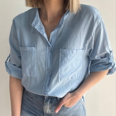 Camisa azul claro com botões e bolsos frontais usada com jeans claros