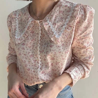 Blusa feminina rosa clara com padrão floral e gola com babados