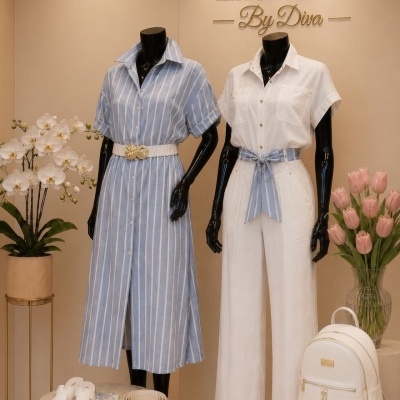 Duas manequins com roupa feminina azul às riscas e branca com cinto, sandálias, lenço e mala