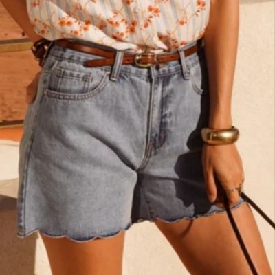 Calções de ganga azul claro com cinto de couro e t-shirt branca com flores laranja