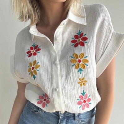 Blusa branca com bordados florais coloridos e botões às pressões