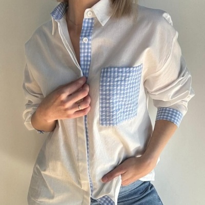 Camisa branca com detalhes xadrez azul e branco e calças de ganga azuis