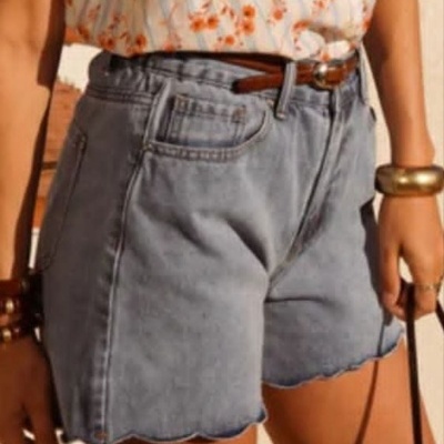 Shorts de ganga azul claro e t-shirt branca com padrão de flores laranja.