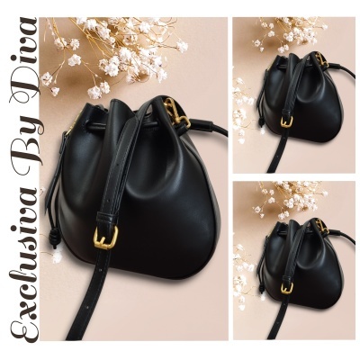 Bolsa tiracolo preta de couro com fecho dourado e flores secas ao fundo