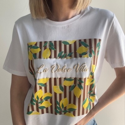 T-shirt branca com estampa de limões amarelos e texto bordado La Dolce Vita
