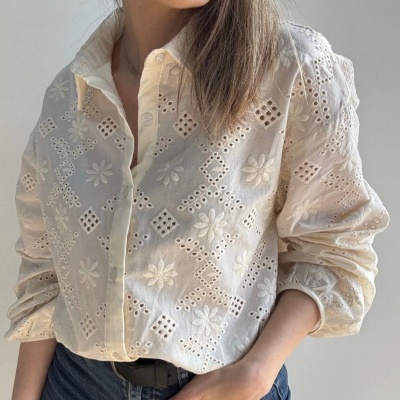 Camisa feminina branca bordada com padrões florais e geométricos