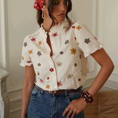 Blusa branca bordada com flores coloridas usada com jeans azul