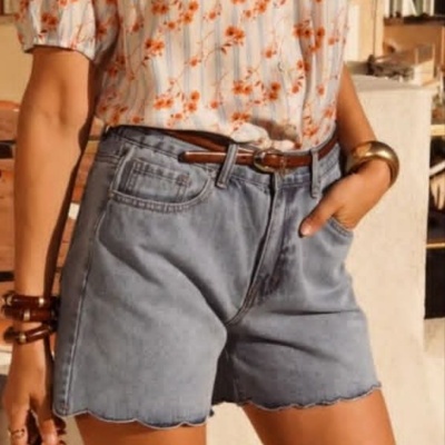 Shorts de ganga azul claro e blusa branca floral em ambiente externo