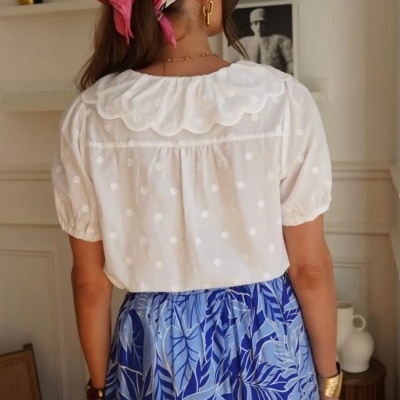 Blusa branca com bolinhas e saia azul estampada vista de costas