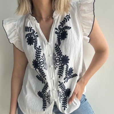 Blusa branca com bordados pretos e folhos nas mangas