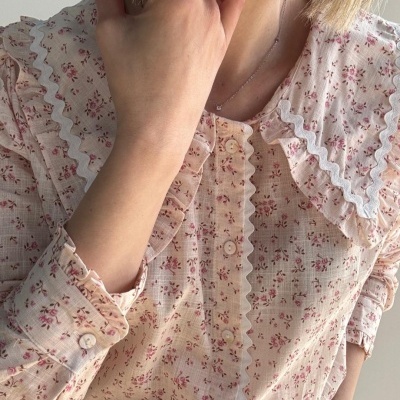 Camisa feminina bege com padrão floral e gola com babados