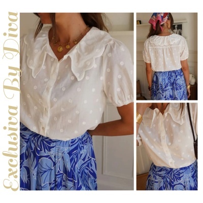 Blusa branca feminina com padrão de bolinhas e gola bordada, combinada com saia azul estampada