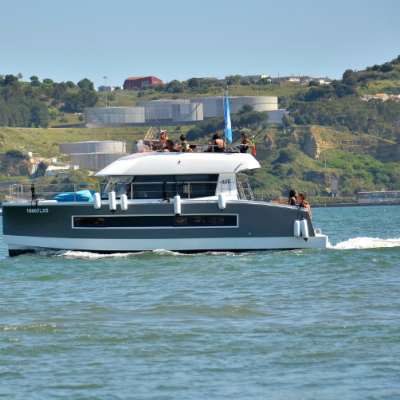 Barco de recreio cinza e branco no mar com pessoas a bordo e colinas verdes ao fundo