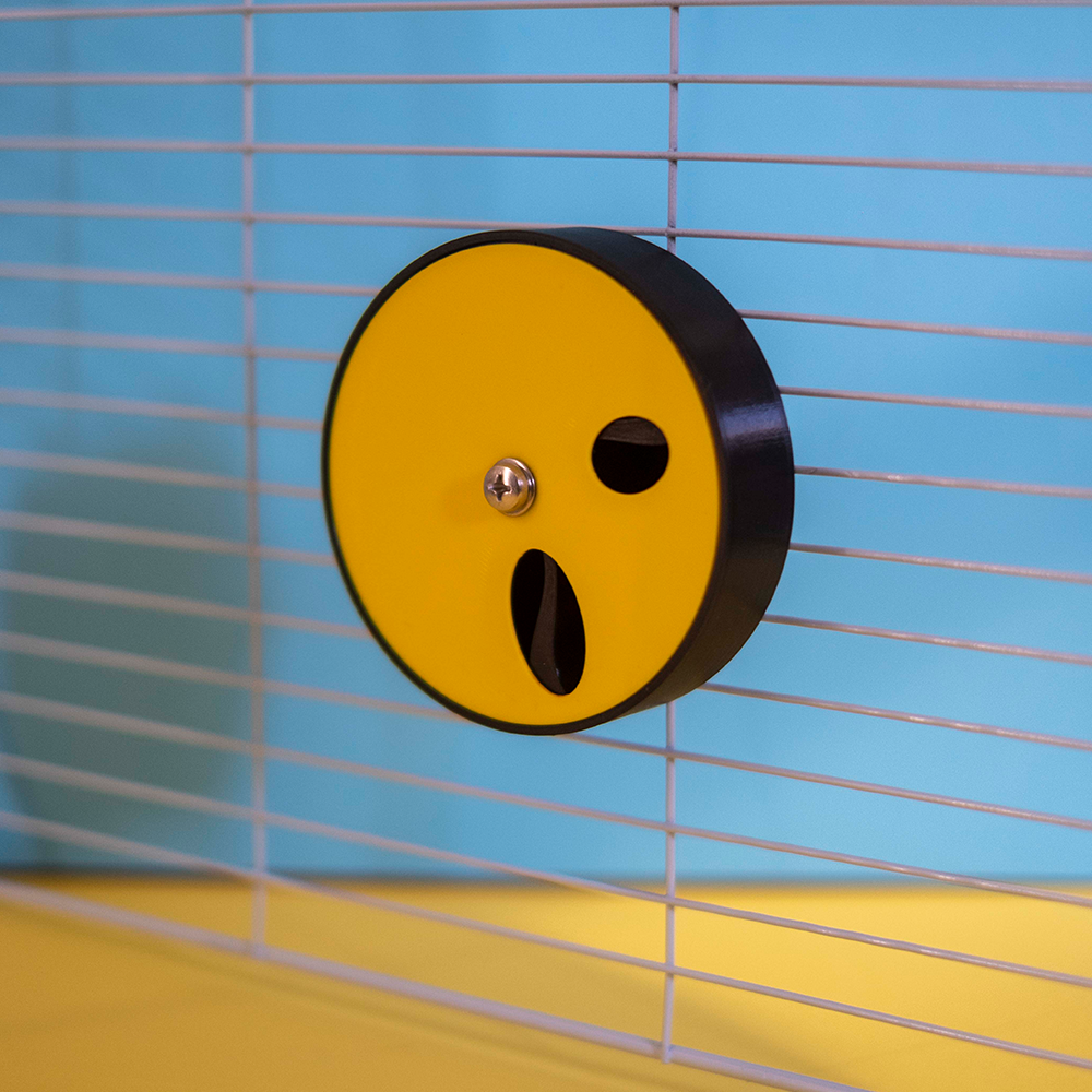 Large Foraging Wheel - tampa com 2 buracos Dispositivo amarelo e preto circular numa grelha metálica branca com fundo azul