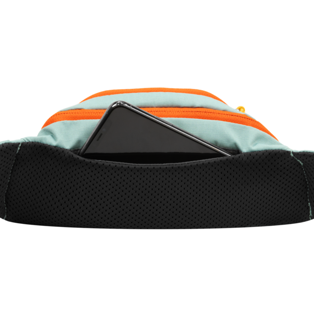 HOME TRAIL™ HIP PACK - River Rock Green - Ruffwear Mochila azul claro com zíper laranja e bolso preto com smartphone