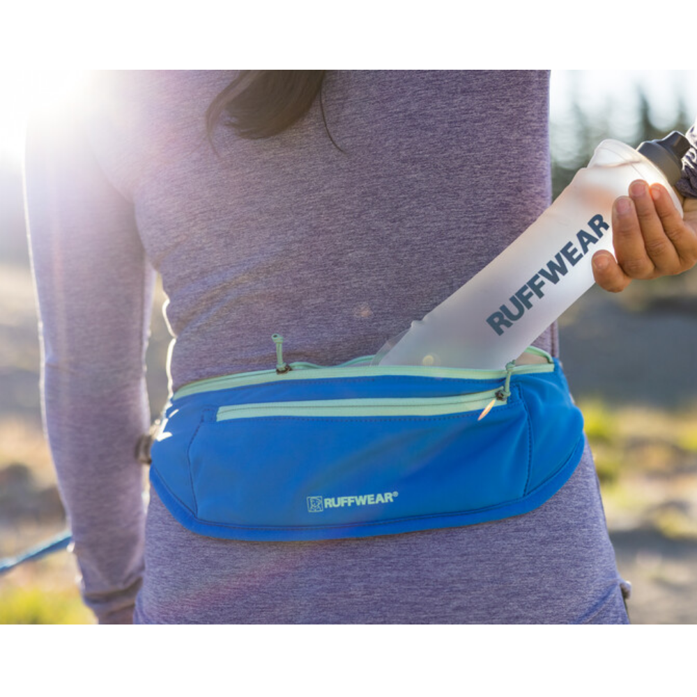 Trail Runner™ Running Belt - Blue Pool Bolsa azul RUFFWEAR na cintura com garrafa plástica RUFFWEAR, roupa desportiva roxa, ambiente exterior