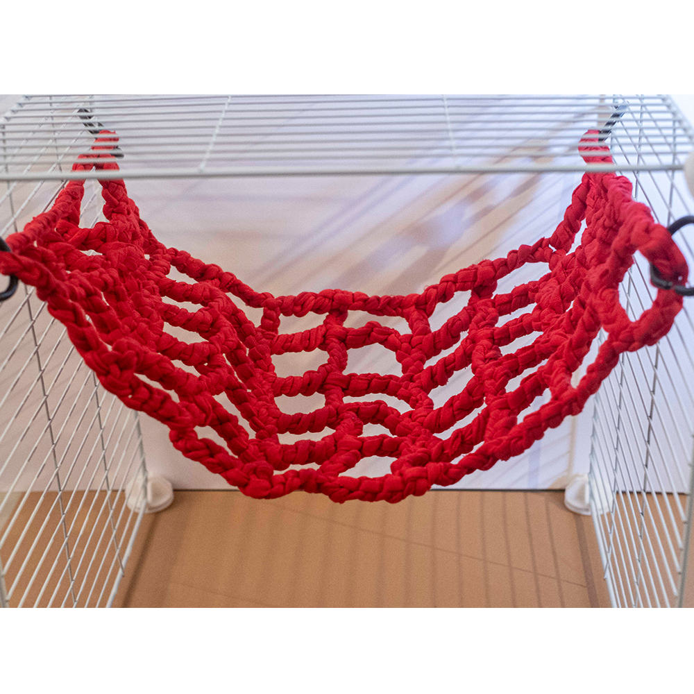 Rede Vermelha em Crochet - Fall Breakers Rede vermelha de corda trançada pendurada numa estrutura metálica branca