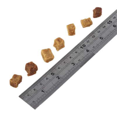 Régua metálica ao lado de pequenos cubos castanhos e bege