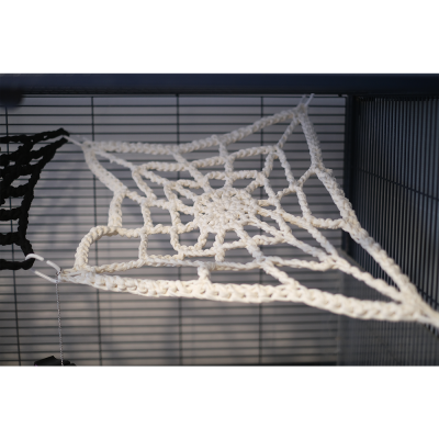 Rede de corda branca em forma de teia de aranha dentro de gaiola metálica