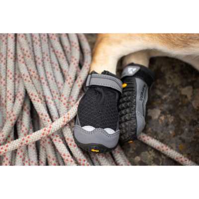 Botas para cão preto e cinza com sola texturizada ao lado de corda branca com padrão vermelho.