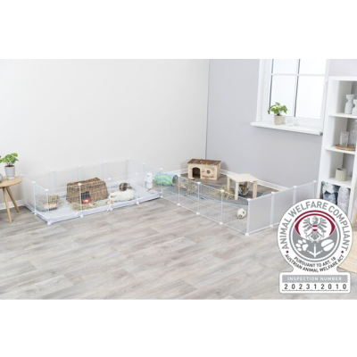 Parque transparente para pequenos animais com acessórios em sala clara.