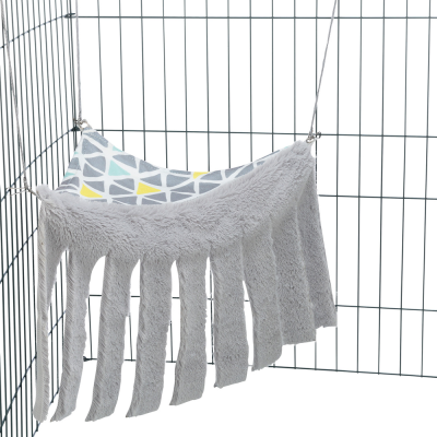 Rede macia cinzenta com franjas e padrão geométrico pendurada numa estrutura metálica para animais