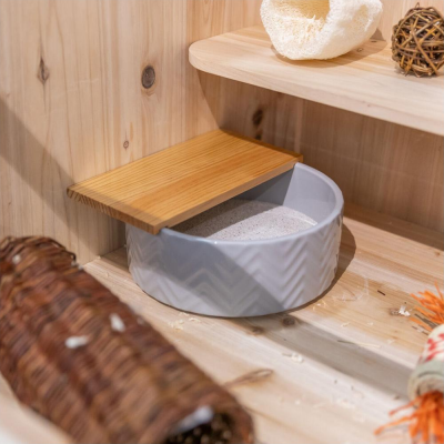 Recipiente redondo cinzento com tampa de madeira numa superfície de madeira clara