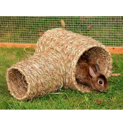 Túnel de fibra natural para coelho com coelho dentro sobre relva