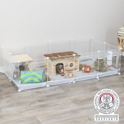 Viveiro branco para pequenos animais com casota de madeira, bebedouro e acessórios dentro.