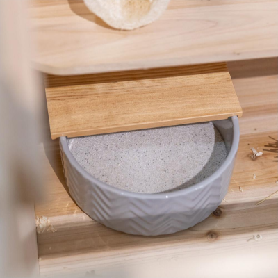 Recipiente cerâmico cinza com tampa de madeira claro sobre superfície de madeira