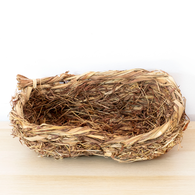 Cesto rústico de palha entrelaçada sobre superfície de madeira