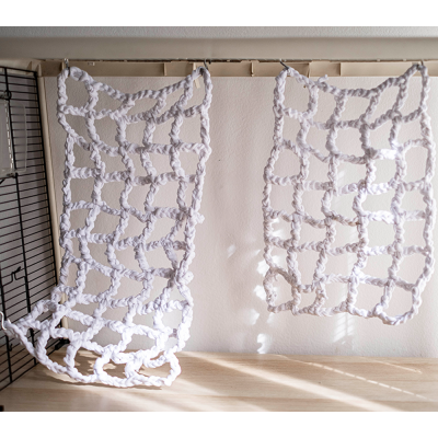 Duas redes de corda brancas trançadas penduradas sobre superfície clara