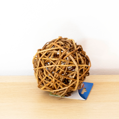 Bola decorativa de ramos naturais entrelaçados sobre madeira clara