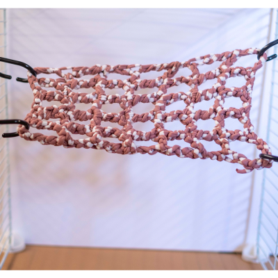 Rede trançada castanho claro e branco pendurada numa estrutura preta