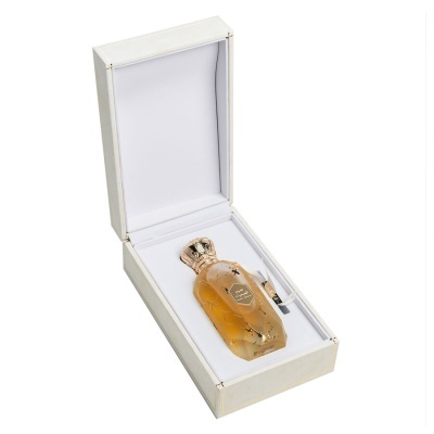 Garrafa de perfume âmbar com tampo dourado em caixa branca acolchoada