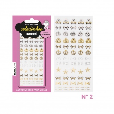 Autocolantes para unhas com padrões dourados e pretos de coroas, estrelas e laços em fundo branco e embalagem rosa