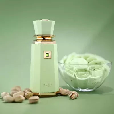 Frasco de perfume verde claro com detalhes dourados e taça com creme verde