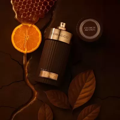Frasco de perfume TOBACCO ZENITH com tampa circular FRENCH AVENUE sobre fundo castanho com laranja e favo de mel.